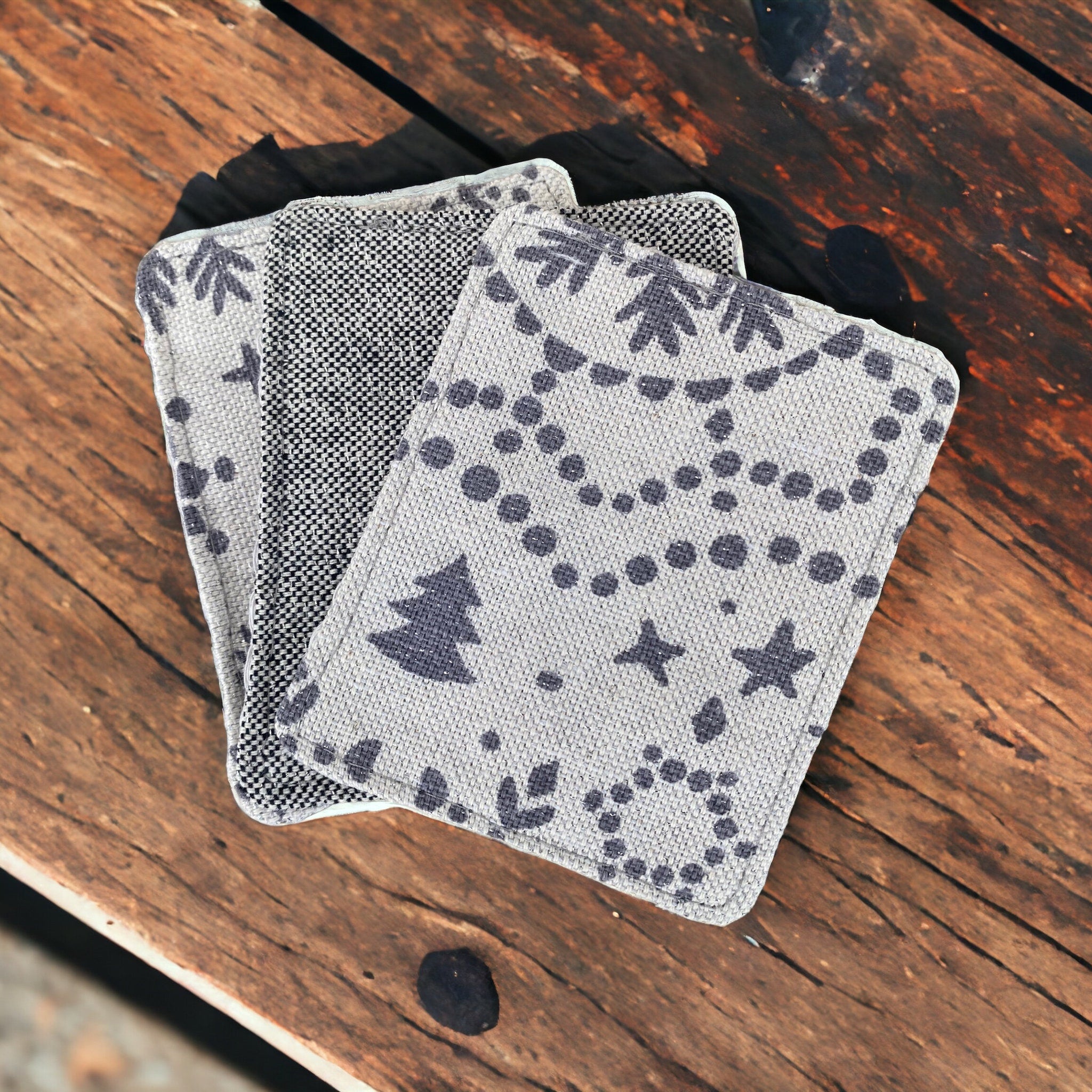 Coasters grey fabric with tree and star pattern on wooden table