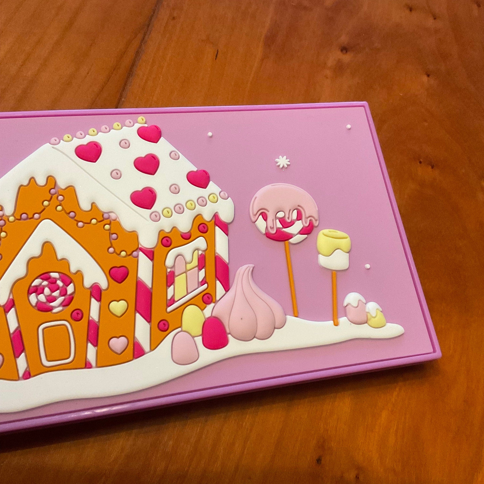 Hand applying shimmery pink eyeshadow from Marshmallow Wonderland palette with a fluffy brush