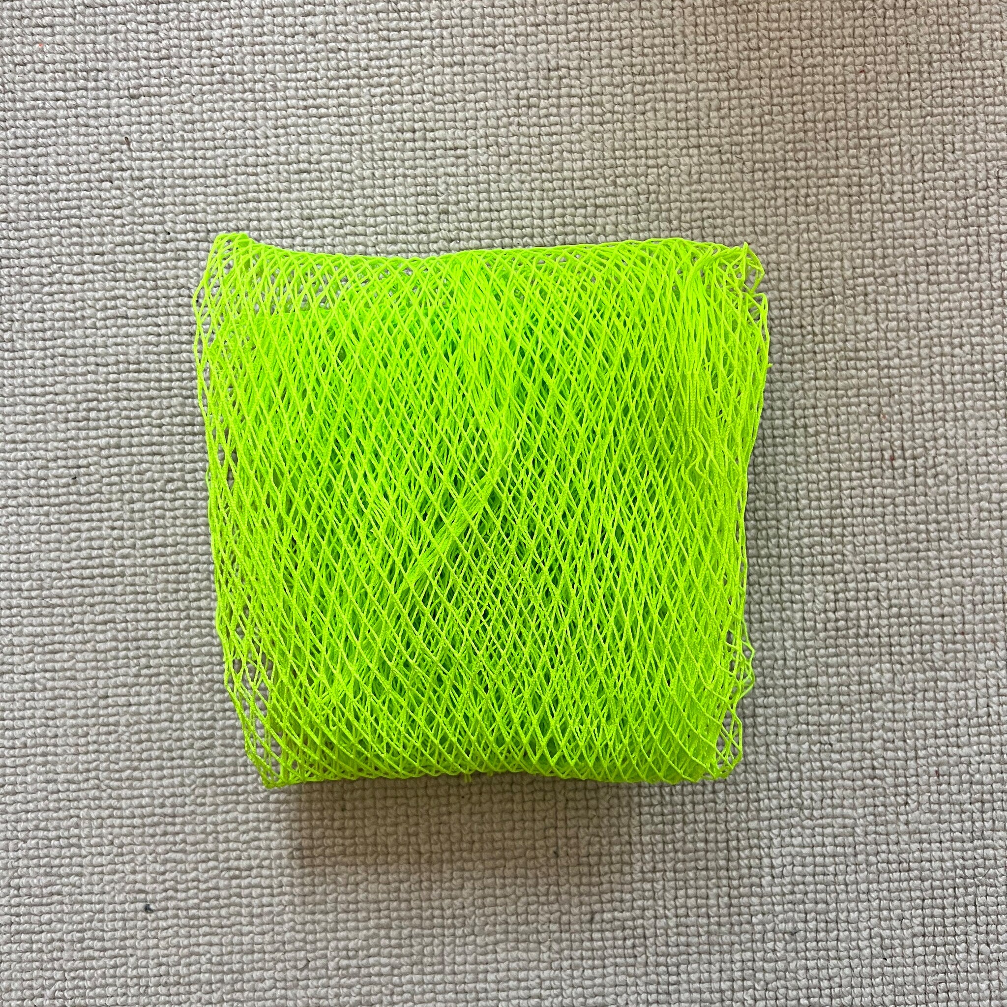 Green mesh material on a textured gray background