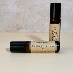 Eyelash and brow oil, brown glass bottle with black cap, Adirondack natural skincare label visible