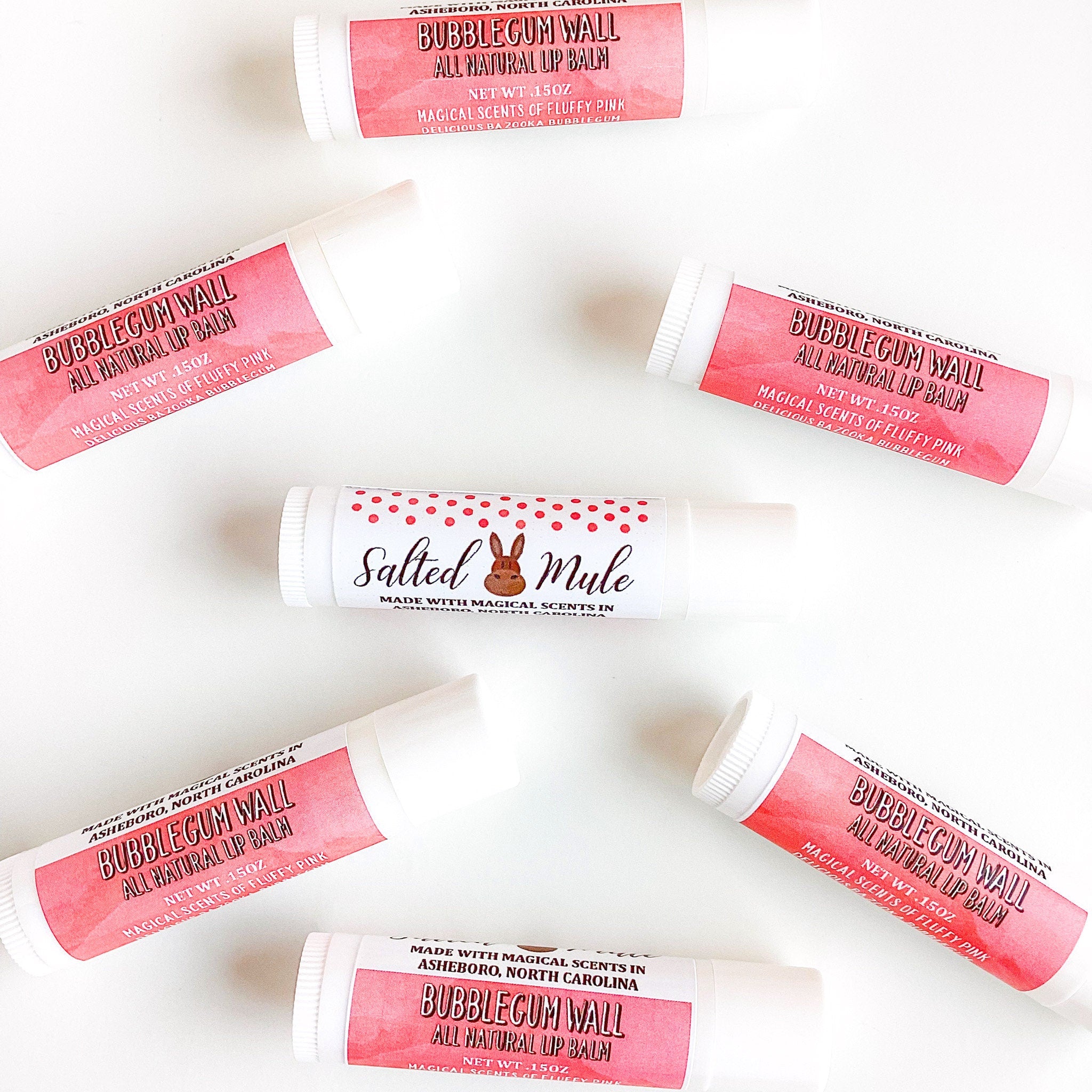 Lip balm tubes with pink labels and white tubes, "Bubblegum Wall" text visible