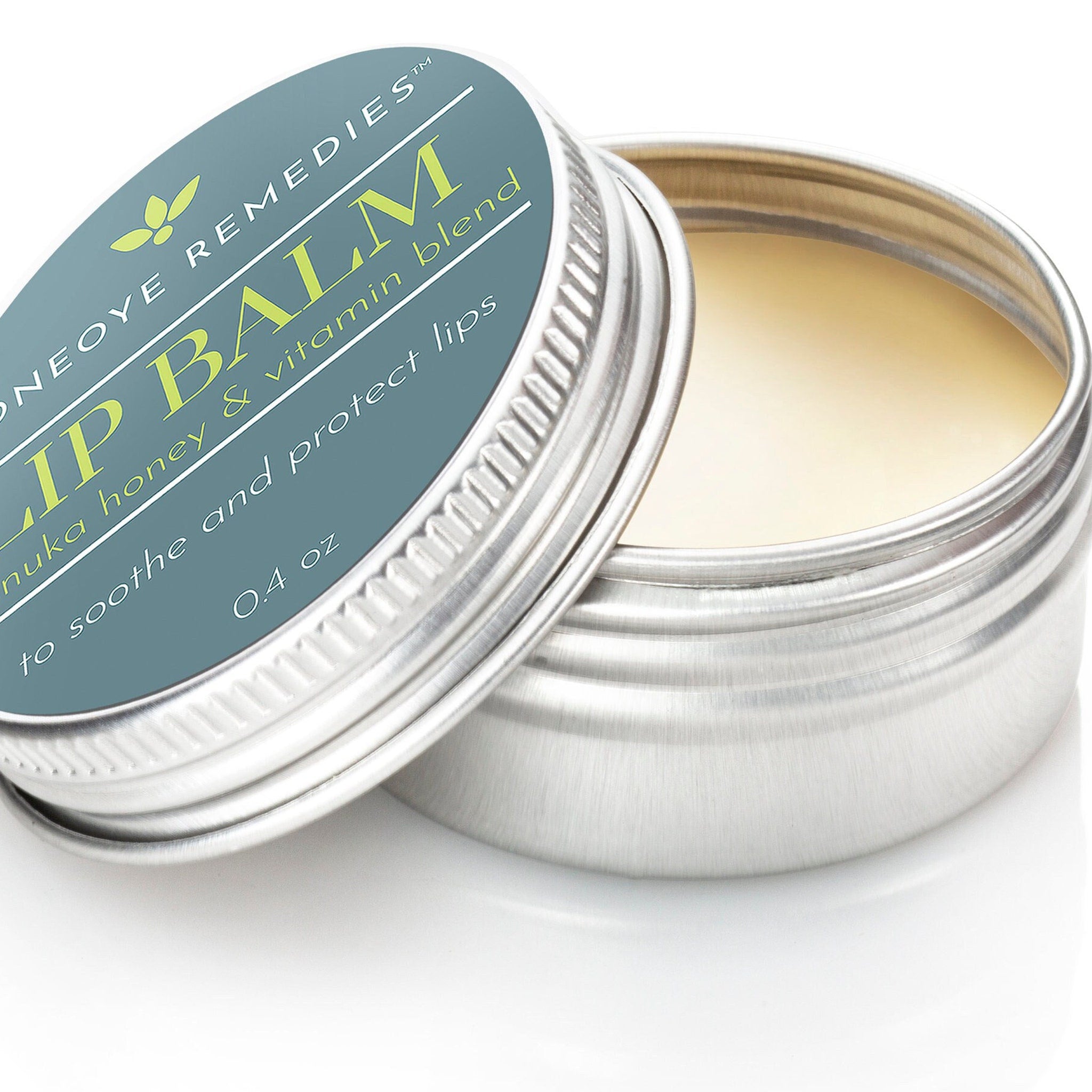 Lip balm in silver metal tin with teal label and yellow balm visible