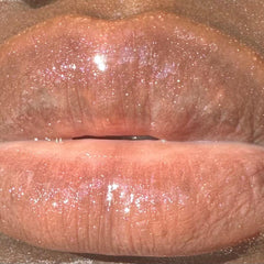 Lip gloss with pink shimmer and glossy finish, close-up of lips
