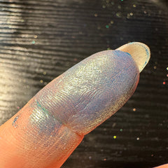 Close-up of green duochrome pressed glitter eyeshadow pan showing shimmering color shift effect