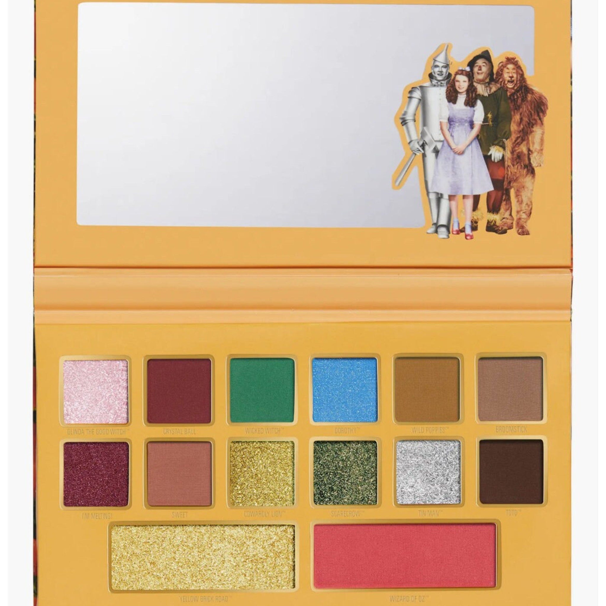Eyeshadow palette with multiple colors, Wizard of Oz theme, and mirror on top.