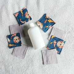 Reusable face pads with koi fish pattern and gray fabric, near white bottle