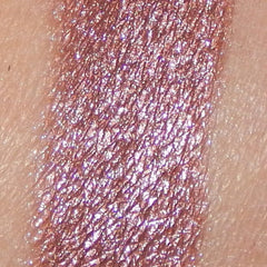 Close-up of shimmery pink mineral eyeshadow with gold flecks in sleek black compact