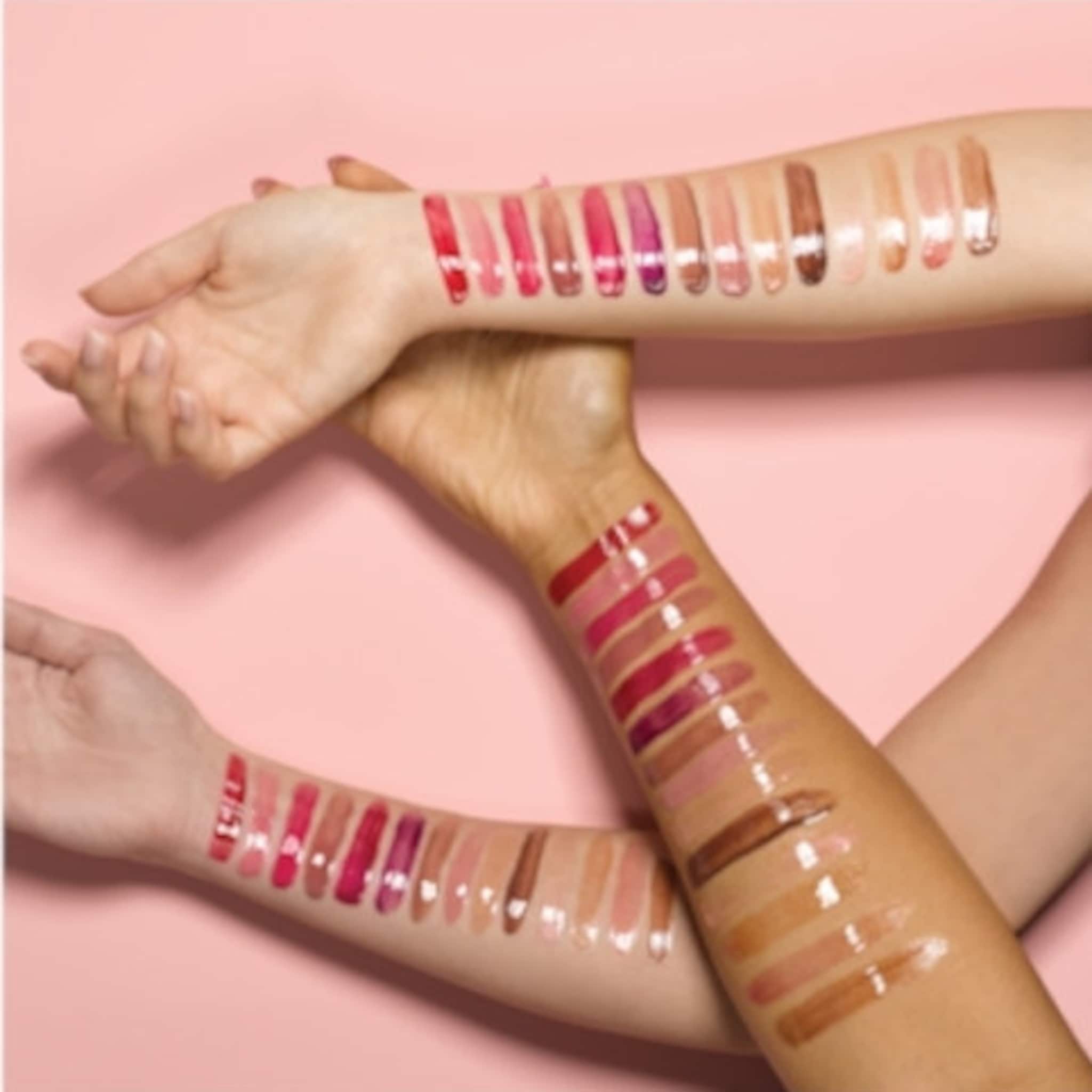 Lip gloss swatches in various shades of pink, red, and brown on arms, glossy finish