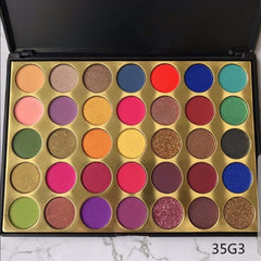 Close-up of shimmering royal blue and gold eyeshadows in sleek black palette with mirror