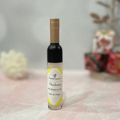 Lip gloss bottle with black, gold, and clear glass, Chamomile Botanicals label visible