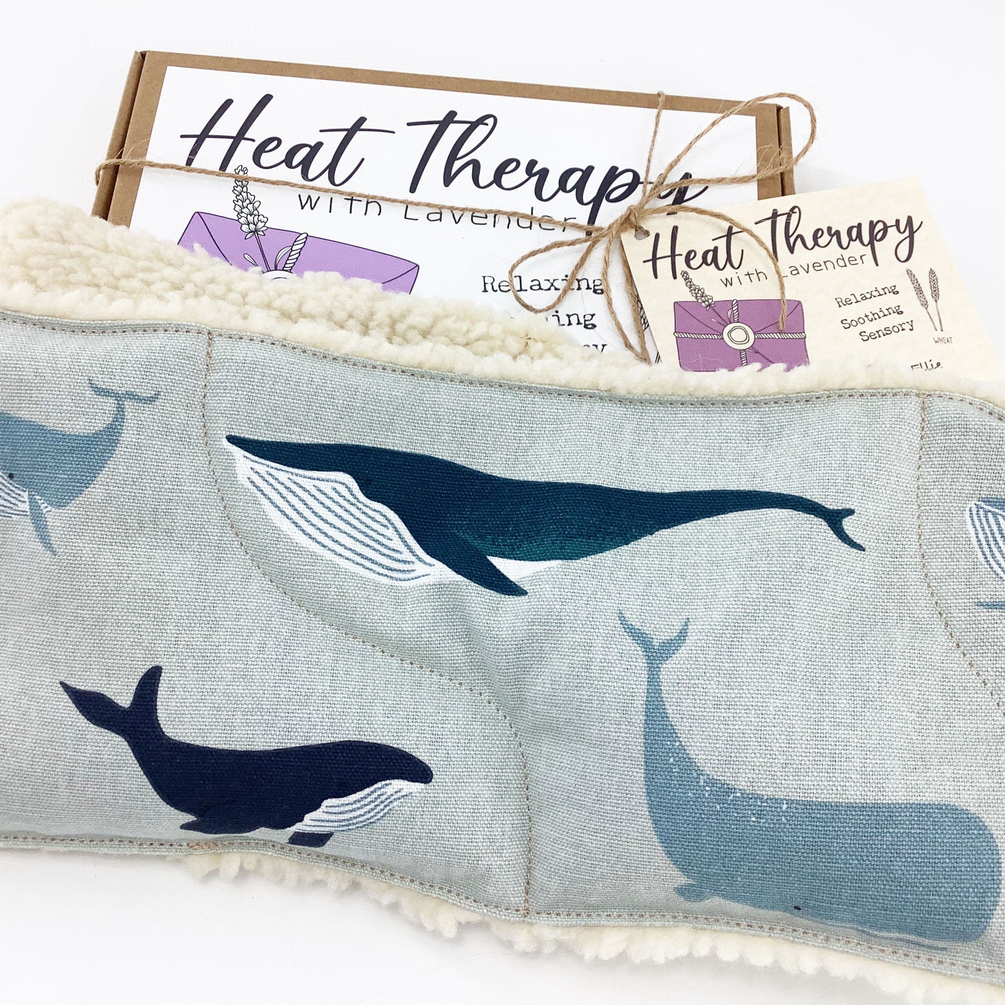 Heat therapy wrap with whale print, light blue fabric, and white fleece trim