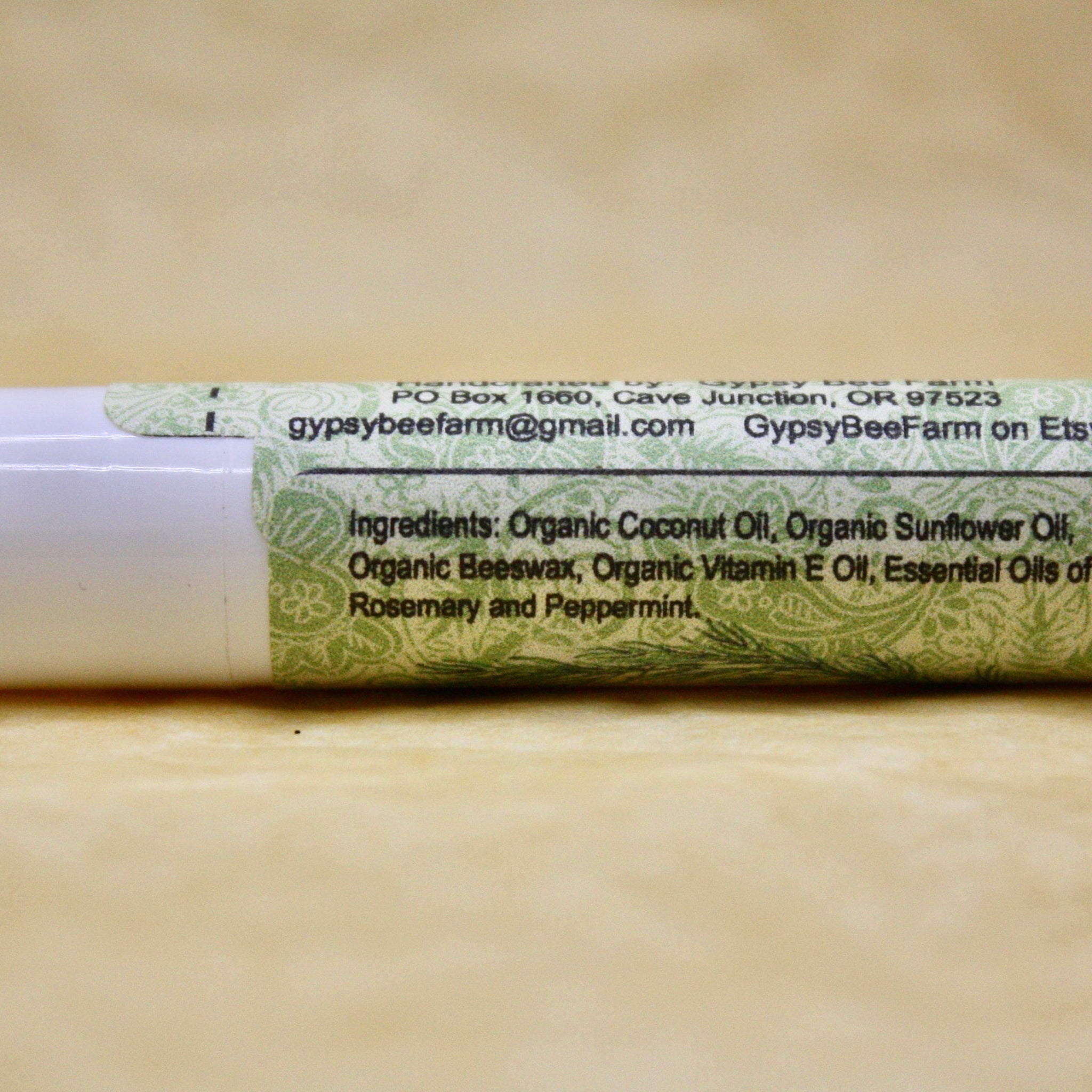 Lip balm tube with white and green label, text from GypsyBeeFarm, ingredients listed