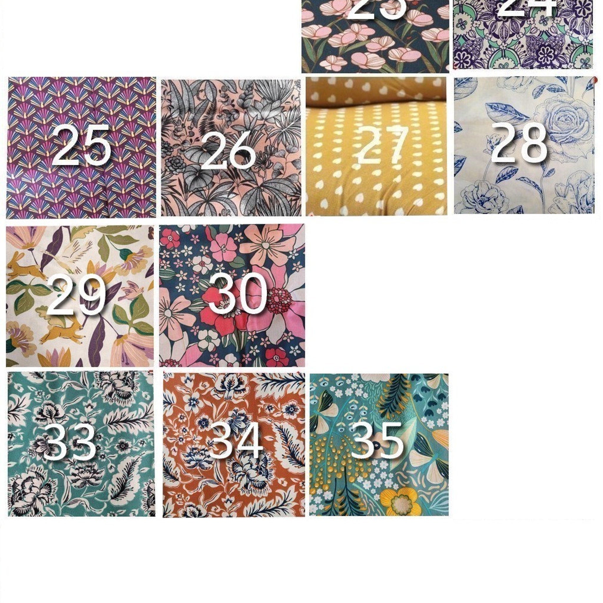 Floral fabric with pink, white, and blue flowers on a dark navy background, floral pattern