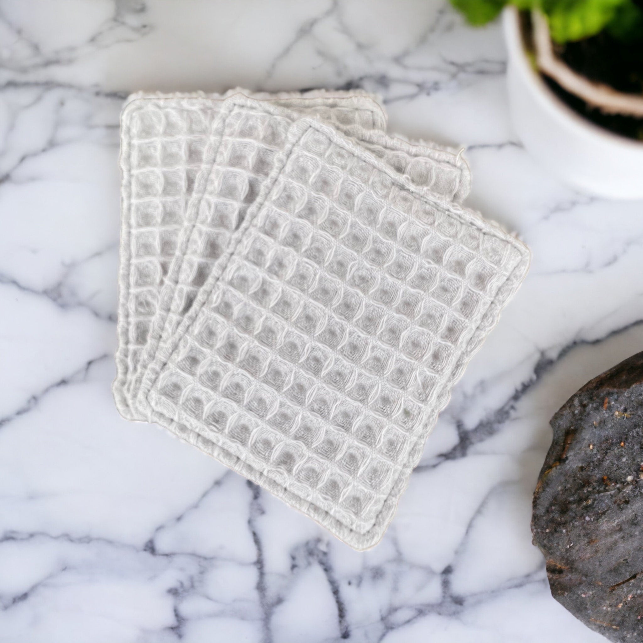Waffle washcloths in light gray with waffle texture on marble surface