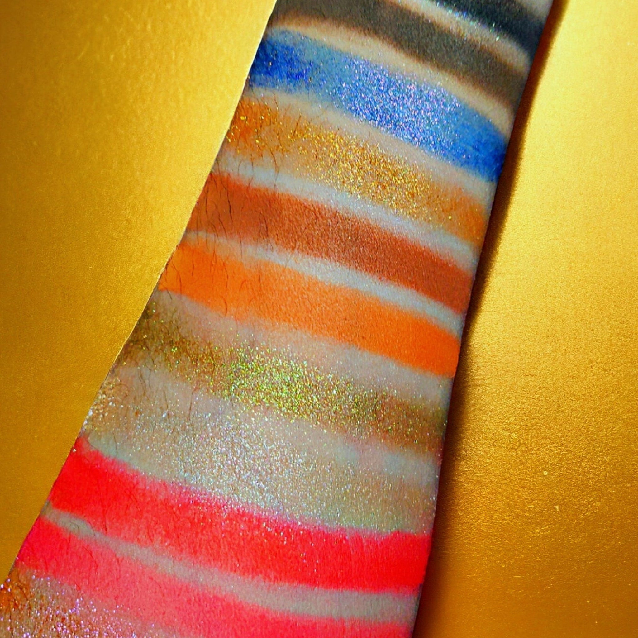 Side view of Boudica Eye Shadow Palette showcasing shimmering bronze and matte taupe shades in sleek black compact