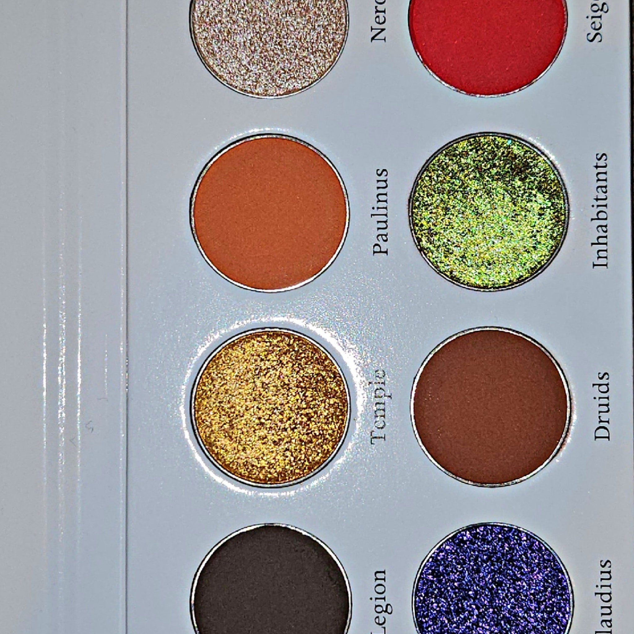 Side view of Boudica Eye Shadow Palette showing sleek black compact with mirrored interior and vibrant color gradient.