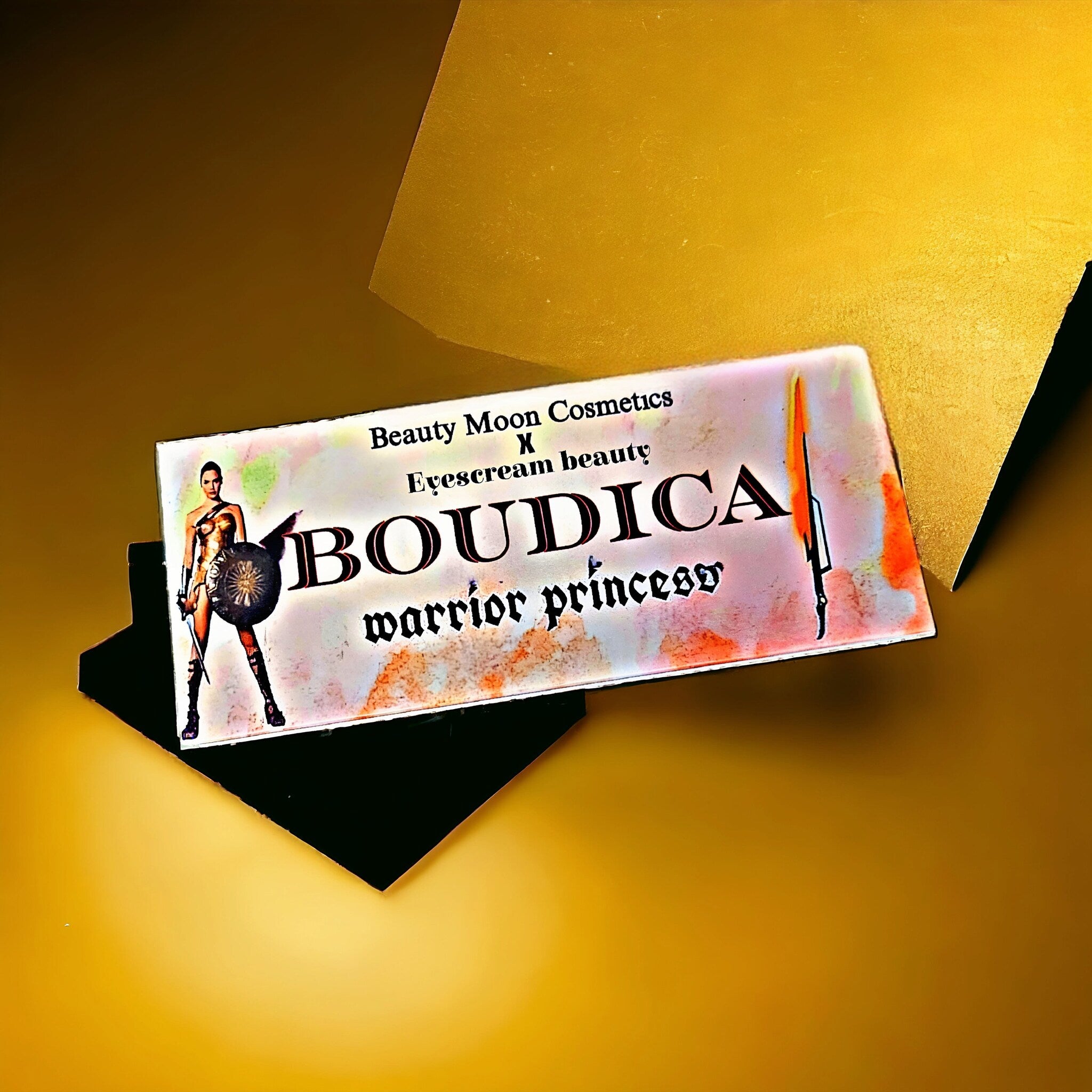 Close-up of Boudica Eye Shadow Palette showing shimmering bronze and deep plum shades with smooth, blendable texture
