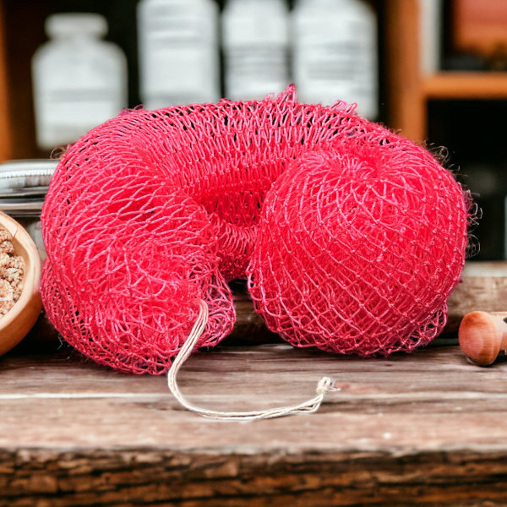 Textured beige exfoliating net sponge draped over bamboo tray with minimalist skincare aesthetic
