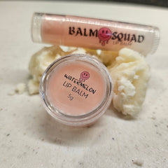 Lip balm with pink color and clear container, "Watermelon" text, and "Balm Squad" branding visible