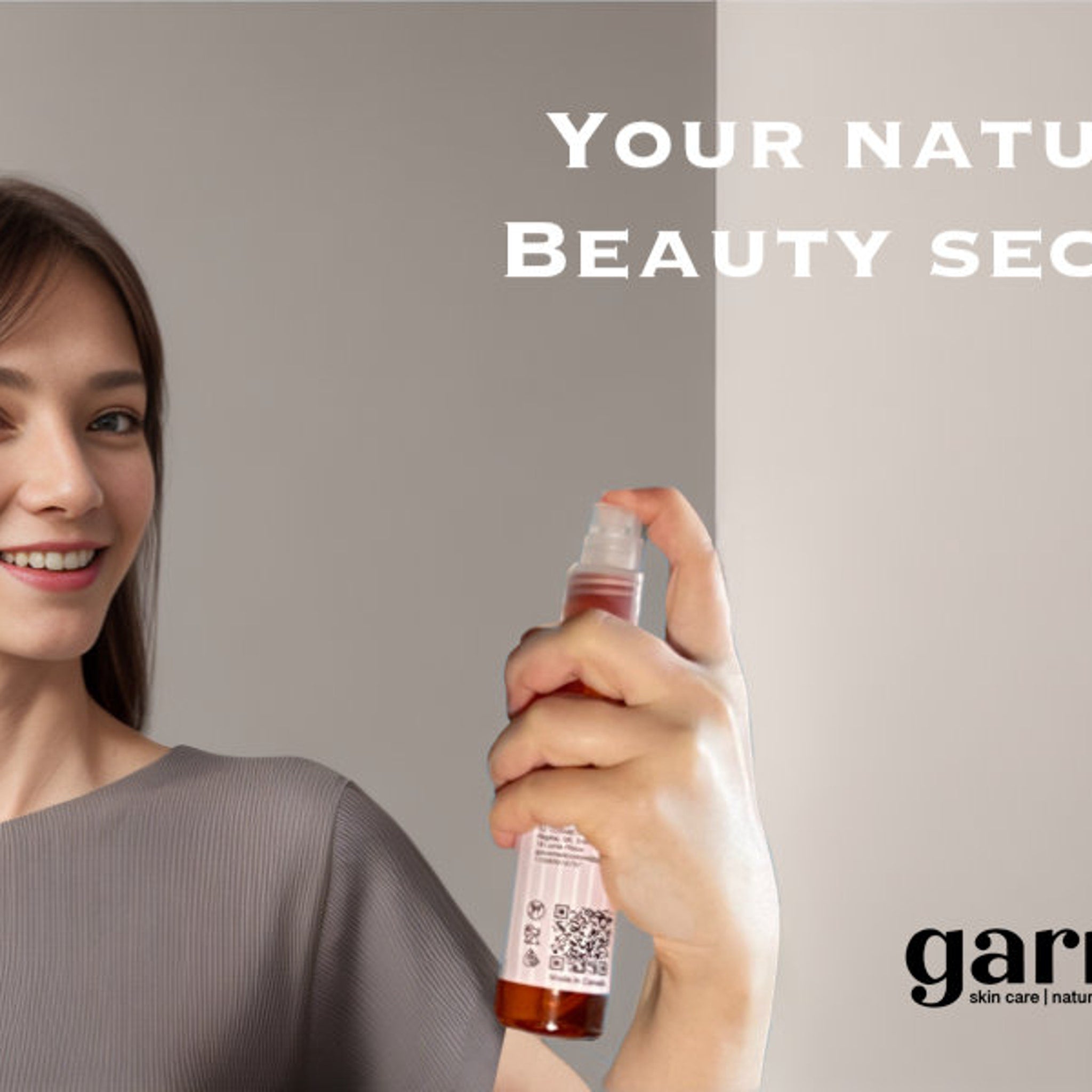 Spray bottle with amber liquid, clear nozzle, held by woman wearing grey top, with "gar" branding