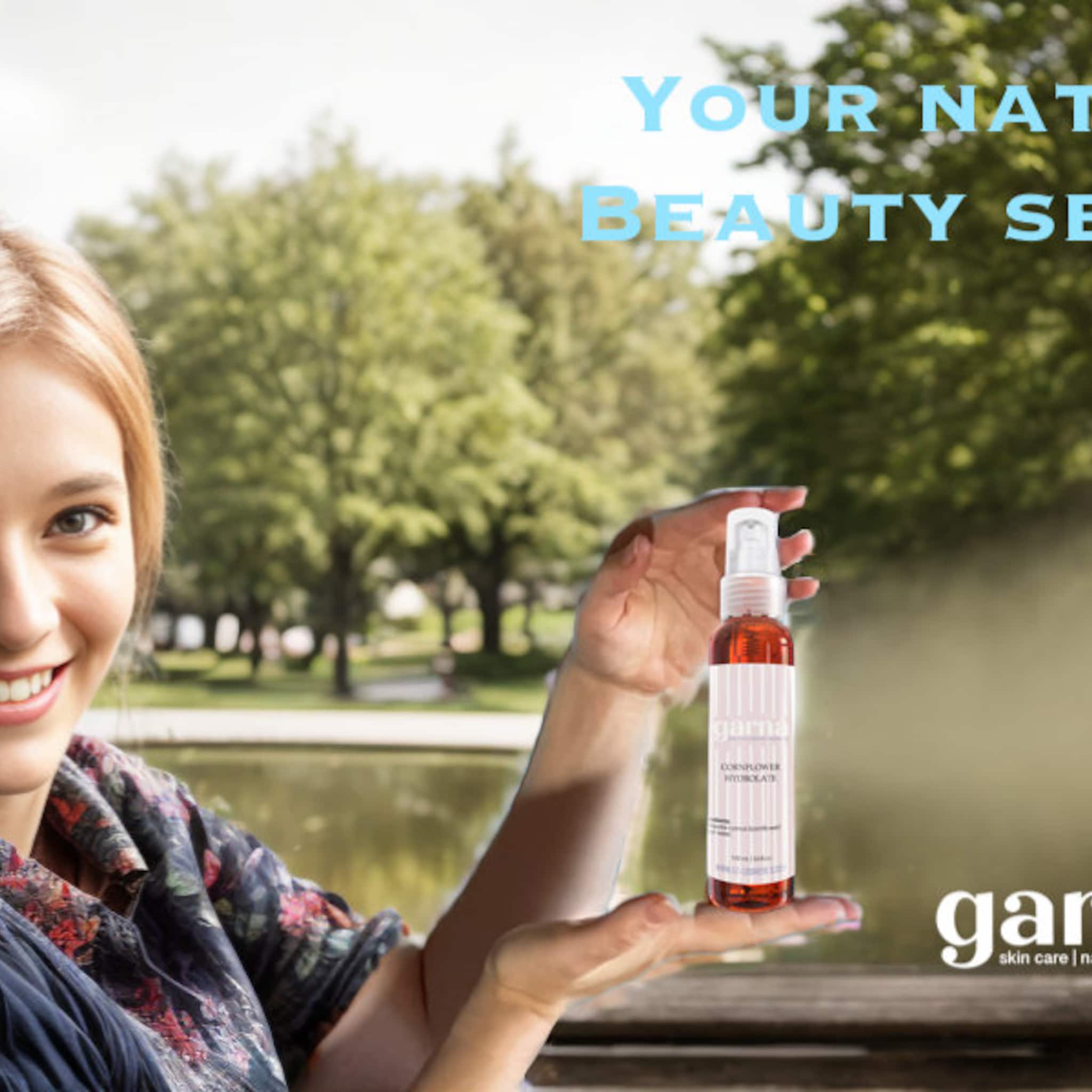 Facial mist bottle, clear plastic with orange liquid, held by woman, "garna" brand visible