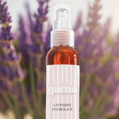 Lavender toner spray bottle, clear plastic with orange liquid, Garna label with vertical lines, lavender background