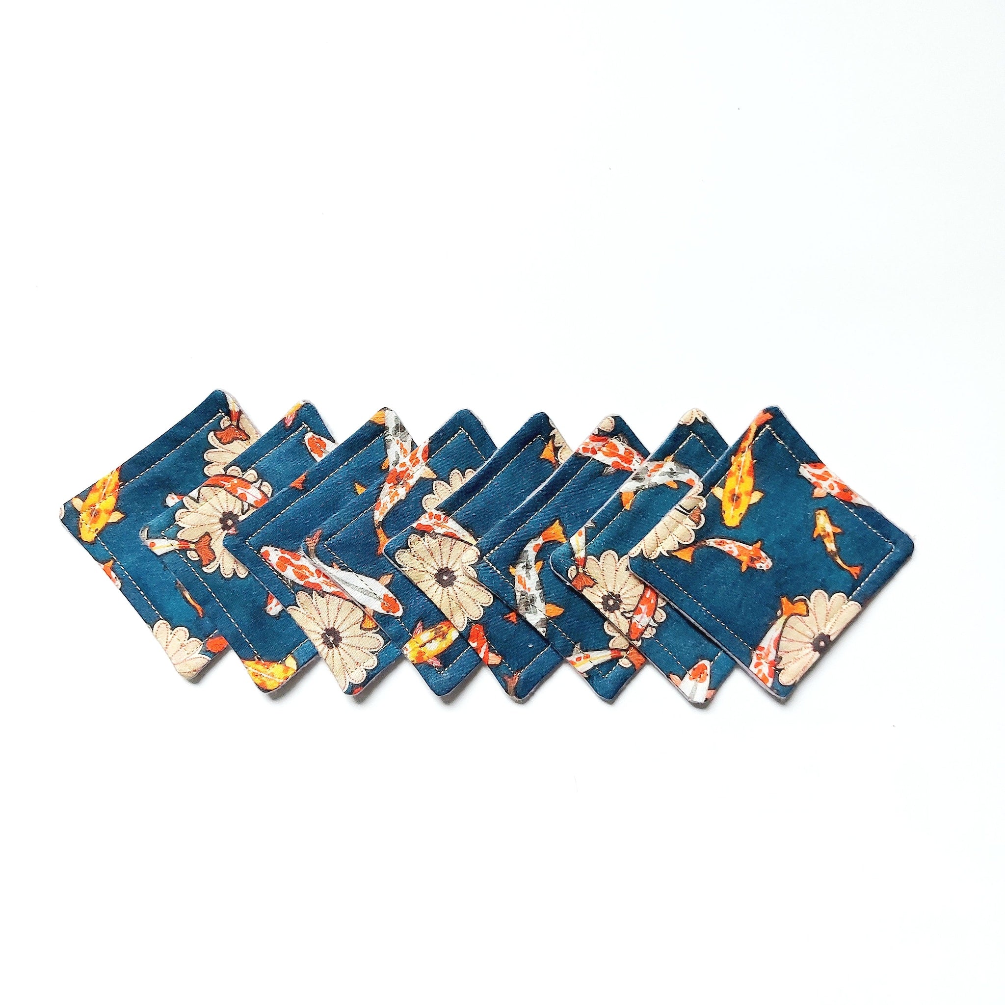 Coasters with teal koi fish pattern and stitched edges, arranged in a row