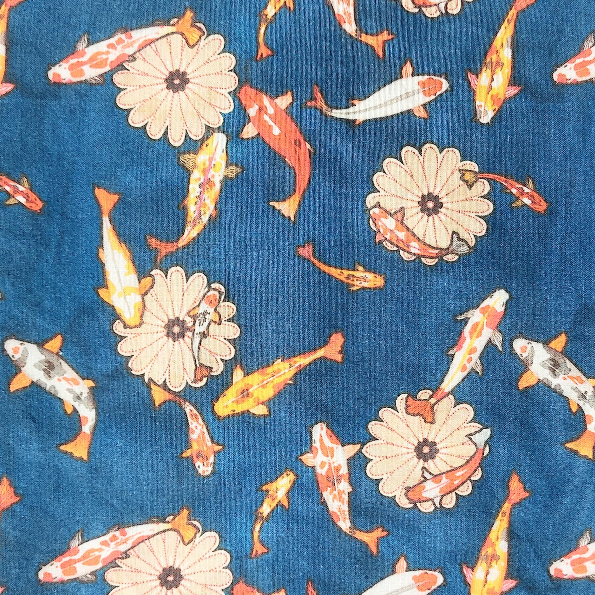 Koi fish pattern on blue fabric with orange, yellow, and white fish and flower shapes