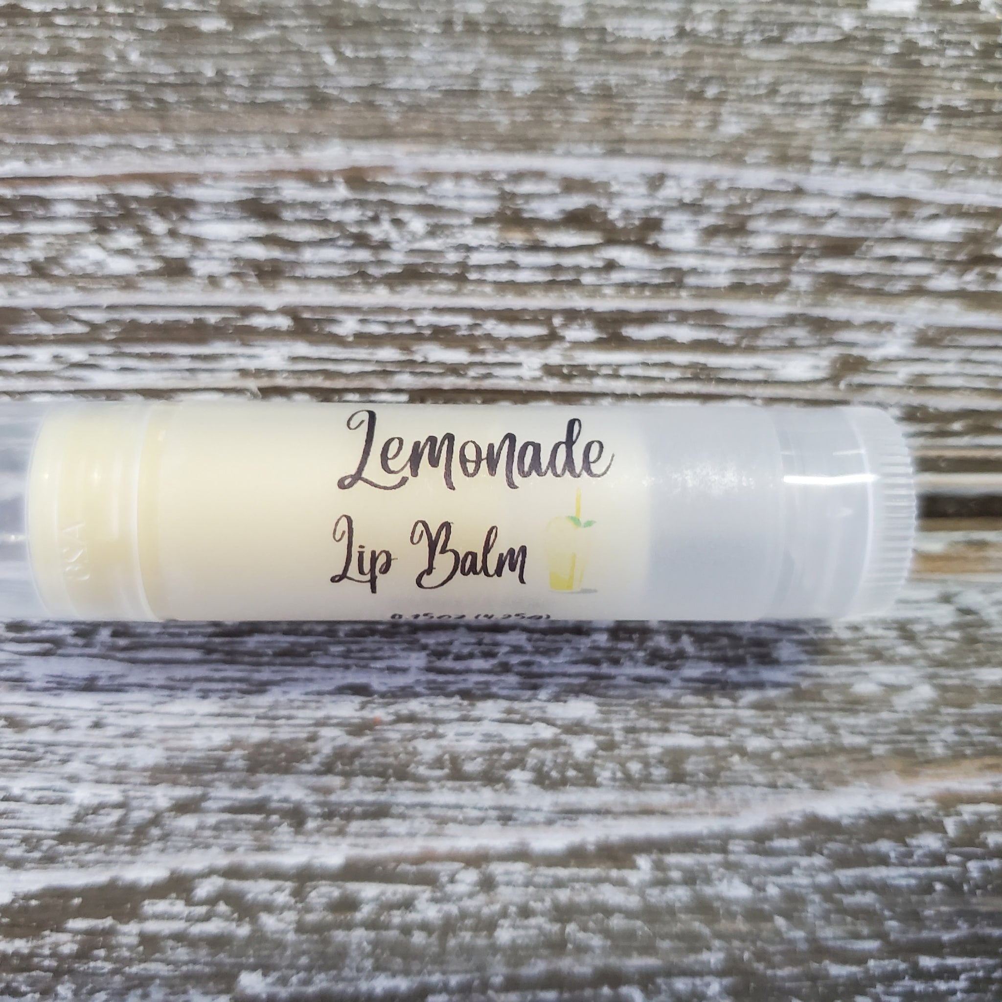 Lip balm tube with white label, yellow balm, and "Lemonade Lip Balm" text