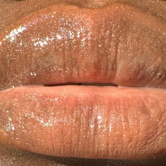 Lip gloss with shimmering glitter, light peach color, and glossy finish on lips