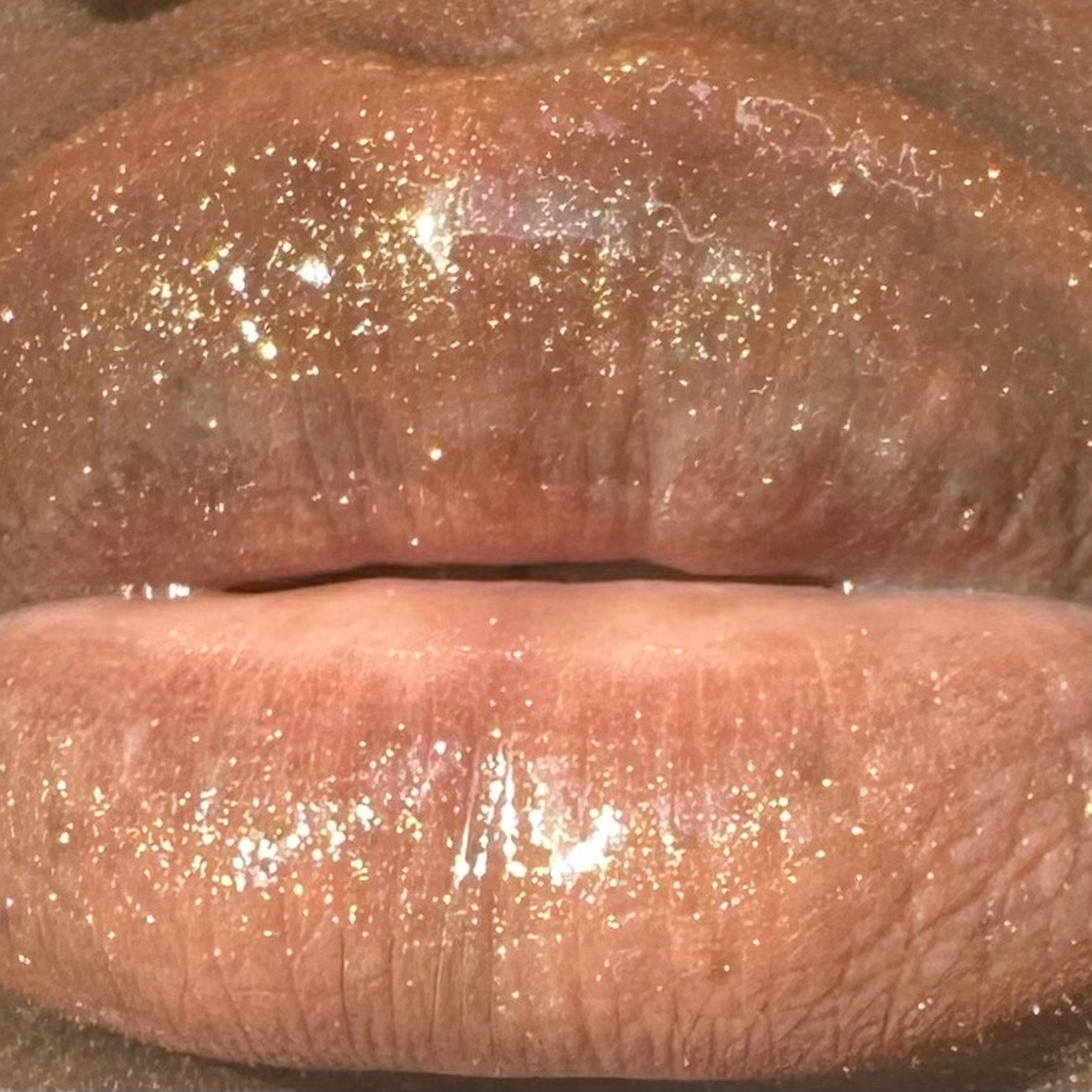 Lip gloss, shimmering gold glitter, glossy finish, close-up of lips