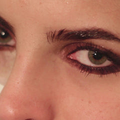 Eye makeup with green eye, brown eyeshadow, and dark eyelashes close up