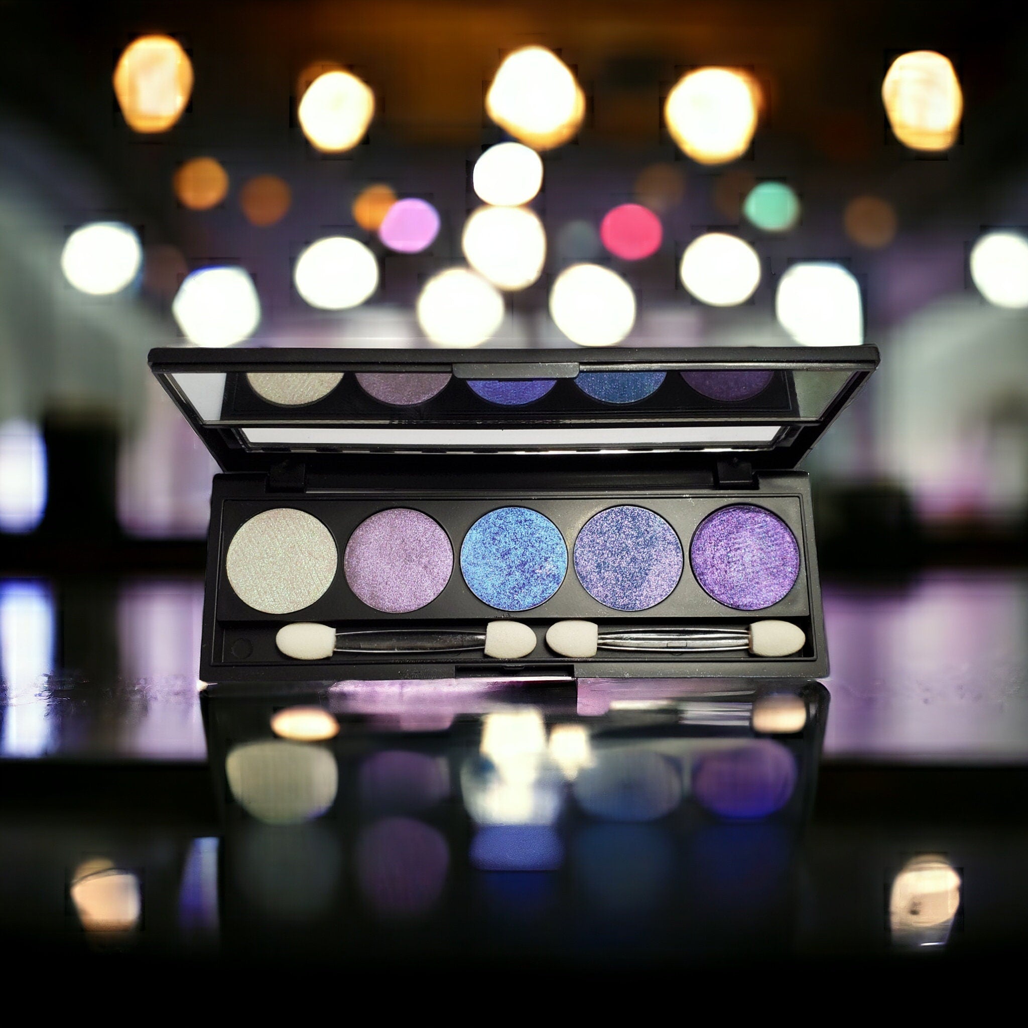 Side view of refillable eyeshadow palette with five duo-chrome shades in a sleek black compact
