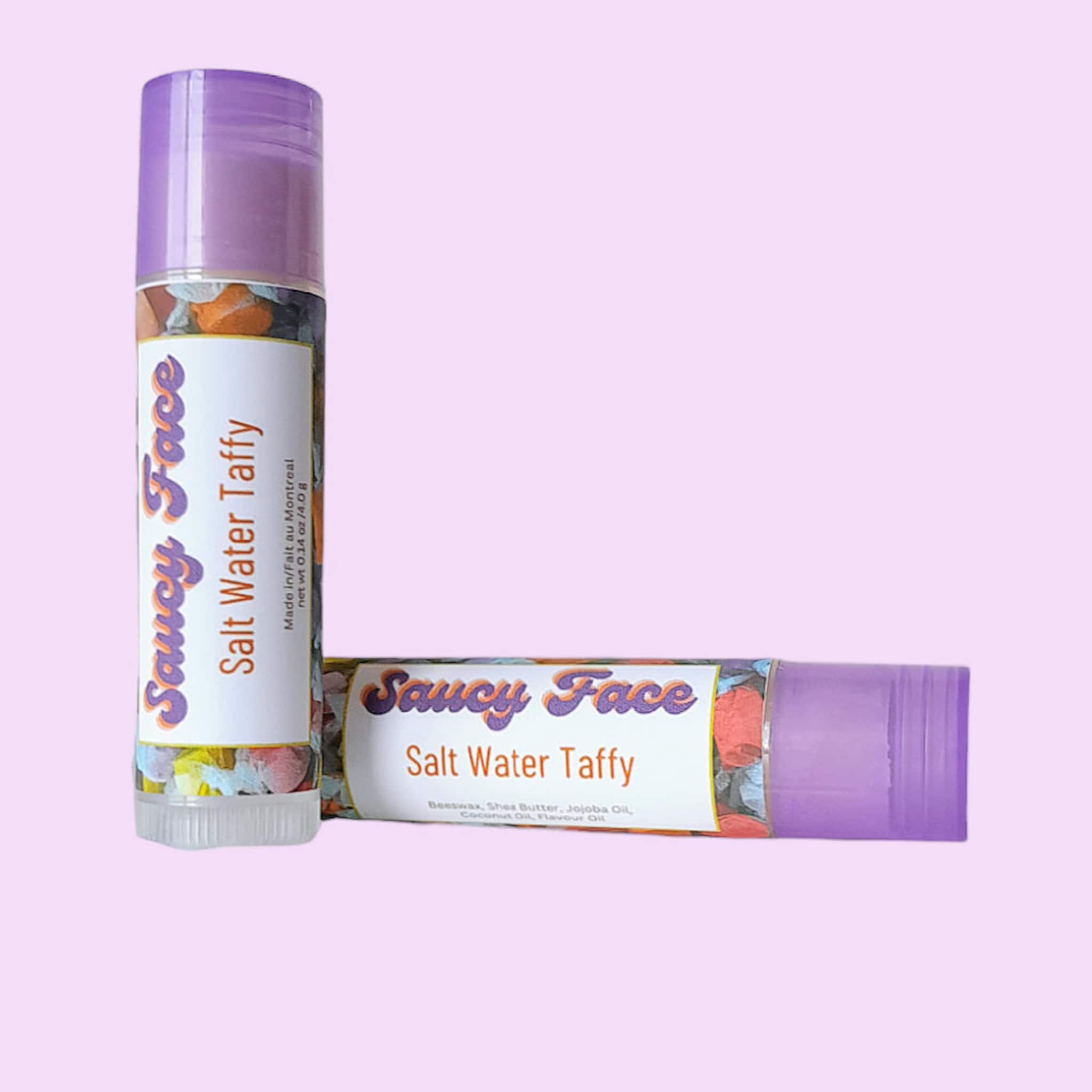 Salt Water Taffy lip balm with purple cap, floral pattern, and Saucy Face branding