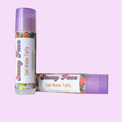 Salt Water Taffy lip balm with purple cap, floral pattern, and Saucy Face branding