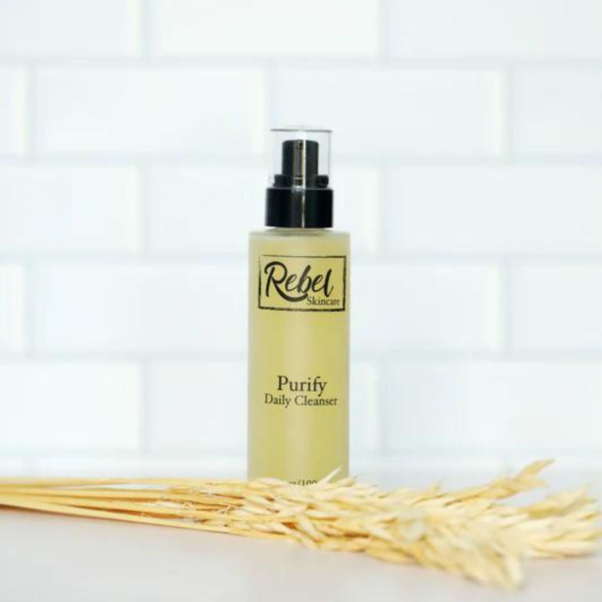 Daily cleanser bottle with black pump, Rebel Skincare label, and yellow liquid inside