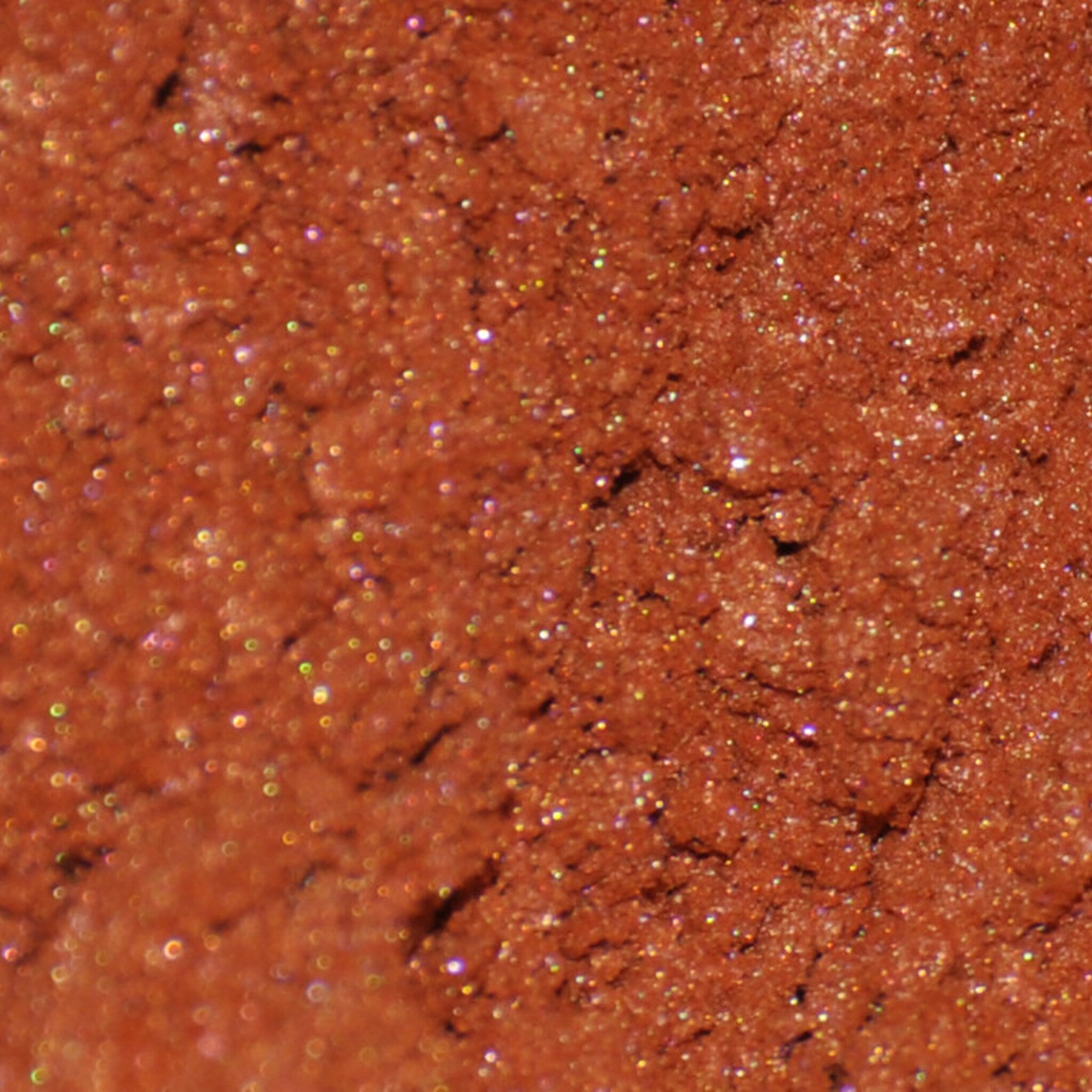 Side view of Phoenix mineral eye shadow jar showing sifter detail and burnt orange powder texture