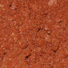 Side view of Phoenix mineral eye shadow jar showing sifter detail and burnt orange powder texture