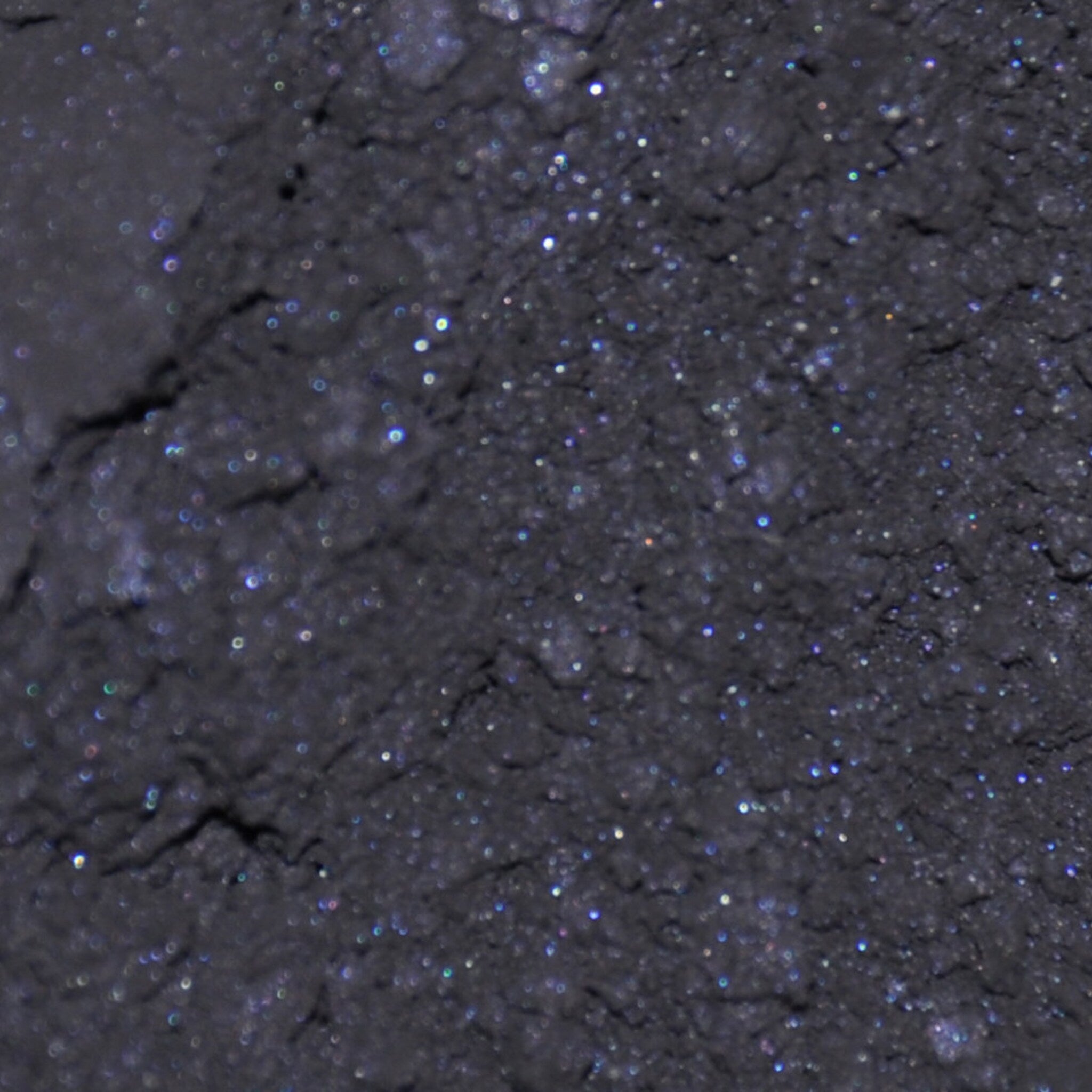 Side view of matte black mineral eye shadow jar with sifter, showcasing compact cylindrical design and product depth
