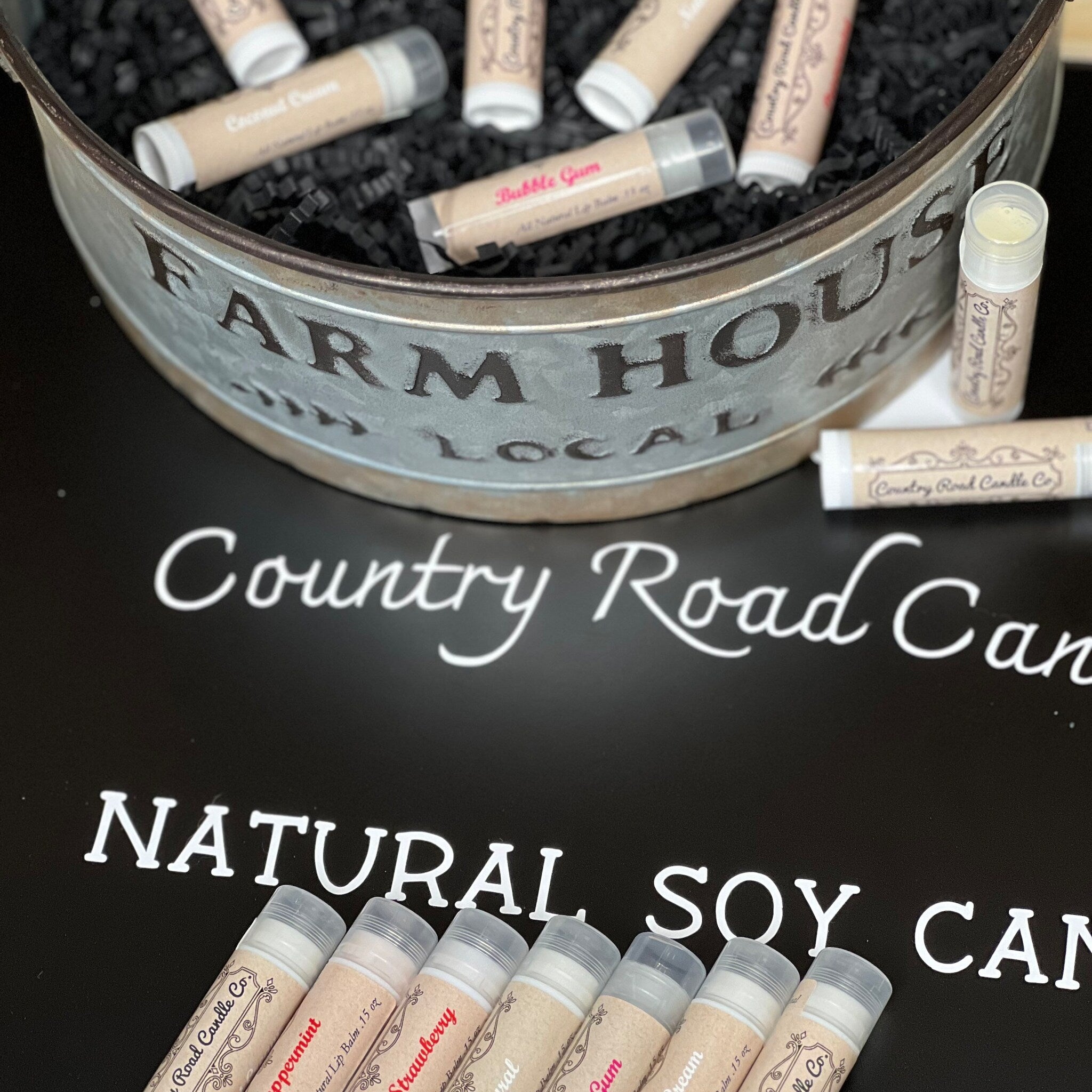 Lip balms with beige labels, clear tubes, and Country Road Candle Co branding displayed together