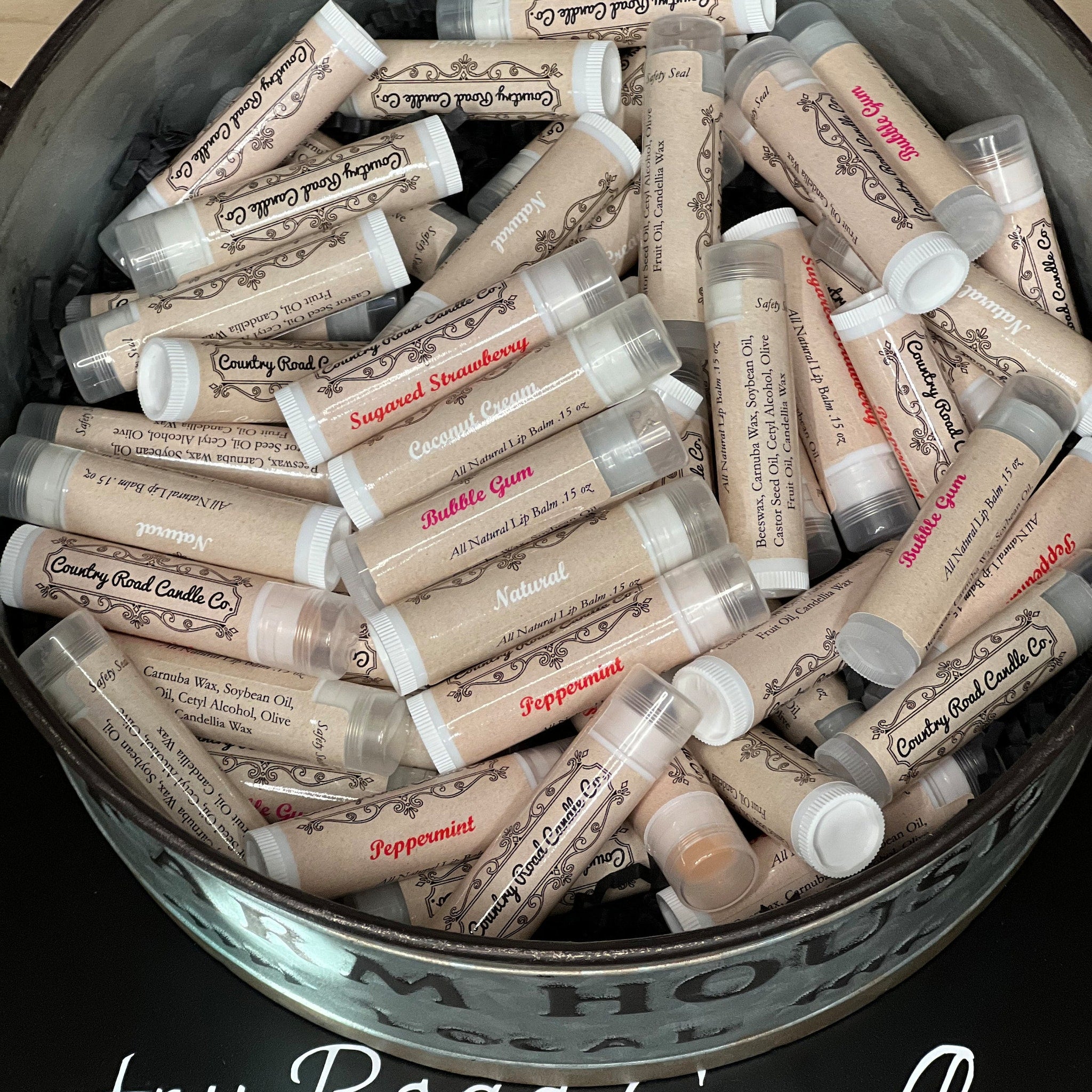 Lip balms in kraft paper tubes with white caps, Country Road Candle Co. branding visible.