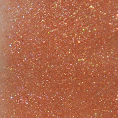 Hand applying shimmery copper mineral eye shadow with a brush from a small jar with sifter