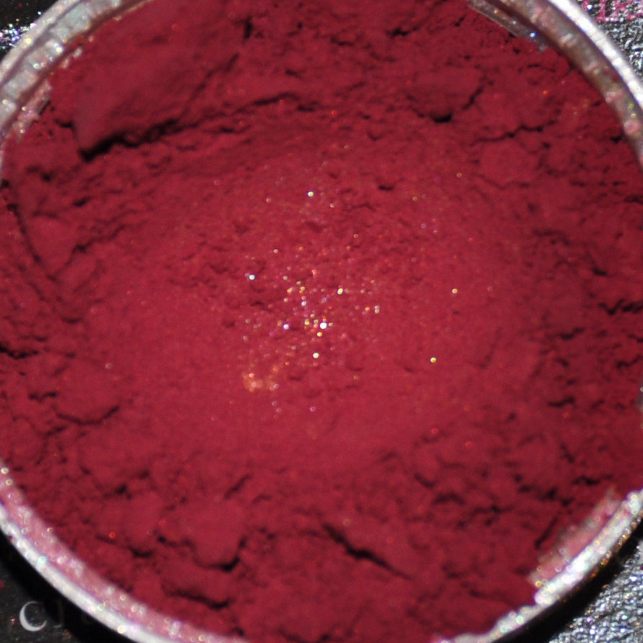 Close-up of deep horror shade mineral eye shadow powder in sifter jar showing rich pigmentation