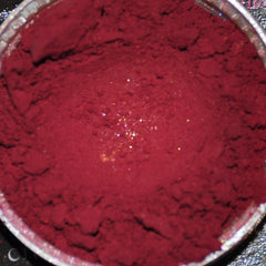 Close-up of deep horror shade mineral eye shadow powder in sifter jar showing rich pigmentation