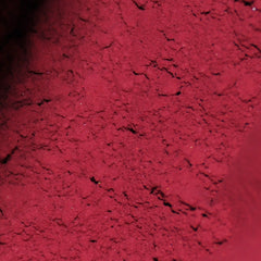 Hand applying pigmented horror shade mineral eyeshadow with sifter jar using a fluffy brush