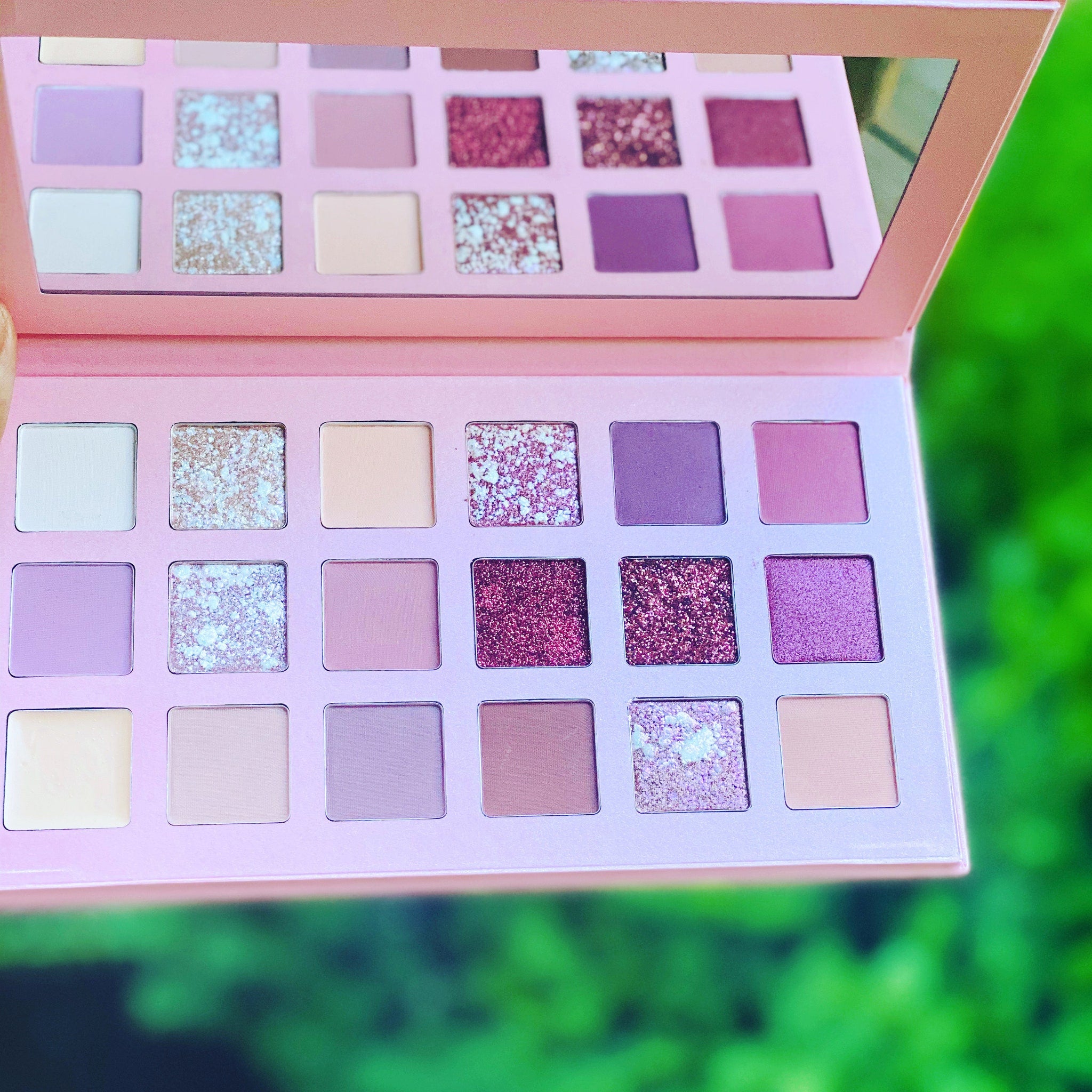 Side view of rose gold eye shadow palette showing six shimmering shades with mirrored compact design