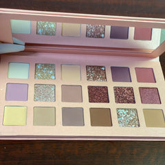 Close-up of shimmering rose gold eyeshadow palette with warm metallic hues and smooth powder texture