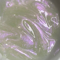 Swirled liquid with green and purple shimmer, white streaks, and glossy texture