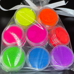 Close-up of vibrant neon pink matte eyeshadow pan with smooth pigmented texture and UV glow effect