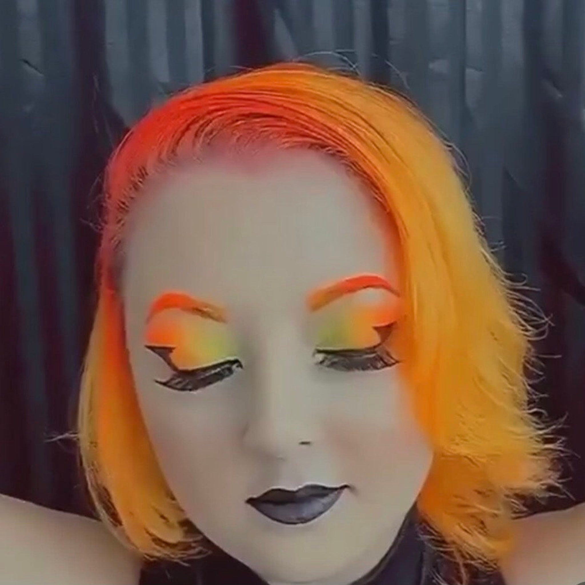 Side view of eight vibrant neon matte eyeshadow pans in fluorescent pink, orange, yellow, green, blue, purple, white, and black